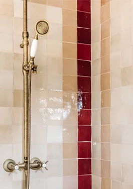Shower walls in beige, pink and red featuring frame pattern 